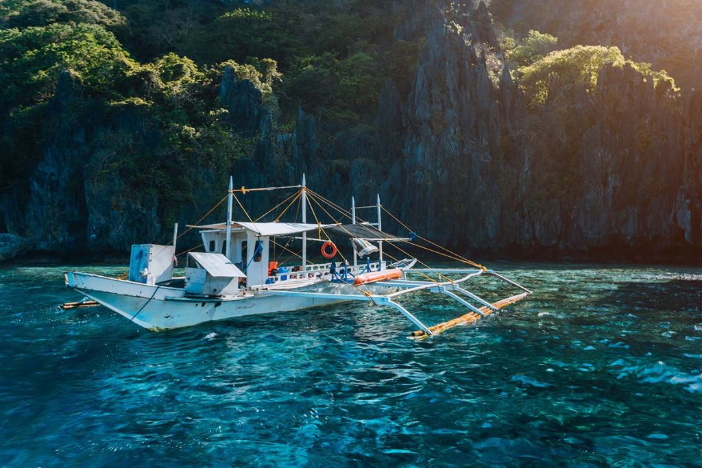 banca local boat on turquoise water against huge l small